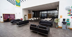 A large room with a couch, chairs, and tables. A clock on the wall. AI generated content