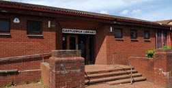 A brick building with a sign on the door that reads “Castle Lodge Library." AI generated content