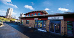 A red brick building with a blue door and a white sign that reads “Welcome". AI generated content